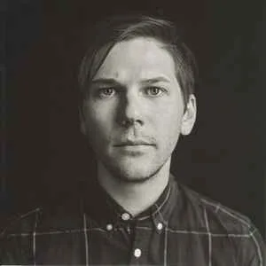Black and white close-up portrait of musician Gregory Pepper, looking directly at the camera.